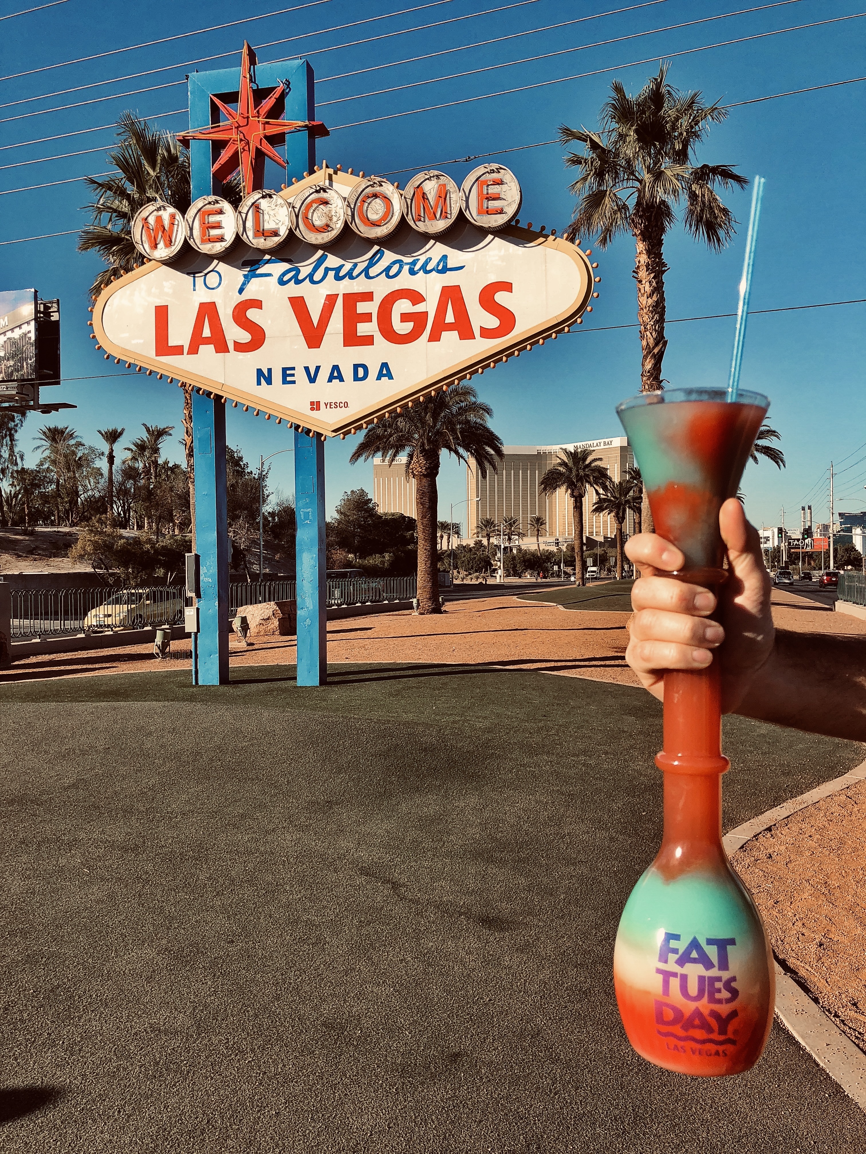 Tall Fat Tuesday cocktail in front of famous Las Vegas sign