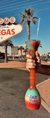 Tall Fat Tuesday cocktail in front of famous Las Vegas sign